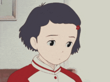a girl with a red flower in her hair is sitting in a chair