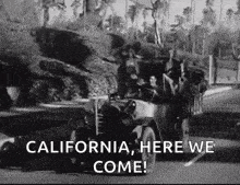 a black and white photo of a jeep driving down a road with the words `` california , here we come ! ''