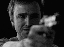 a close up of a man holding a gun in his hand