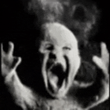 a black and white photo of a baby screaming with its mouth open
