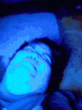 a pixelated image of a person sleeping with a blue light shining on their face
