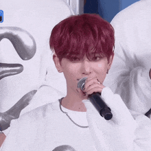 a person with red hair is holding a microphone