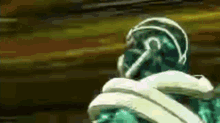 a green and white cartoon character with a white scarf around his neck is standing in front of a brown background .