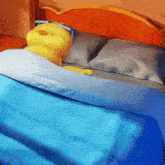 a yellow stuffed animal is laying on a bed