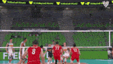 a group of volleyball players are playing a game in front of a volleyball world banner