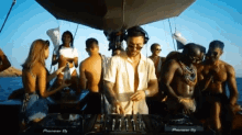 a group of people are gathered on a boat with a pioneer dj