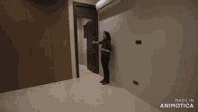 a woman stands in an empty room with the words made in animotica on the bottom