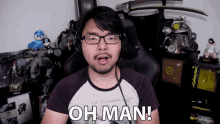 a man wearing glasses and headphones says " oh man "