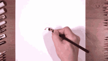 a person is drawing a face with a pencil