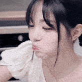 a close up of a woman making a funny face while eating a piece of food .