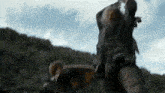 a man is riding a horse in a field while another man holds a sword .