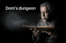 a man holding a book with the words dom 's dungeon behind him
