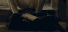 a man is sitting on the floor using a cell phone .
