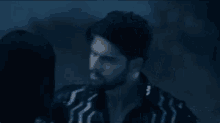 a man and woman are kissing in front of a car with a blue light coming out of it .
