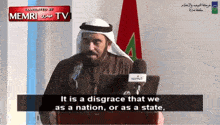 a man is giving a speech in front of microphones and a sign that says memri tv on it