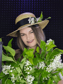 a woman wearing a straw hat and holding flowers