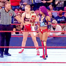 two women in a wrestling ring with one wearing a shirt that says hot kennel 1996