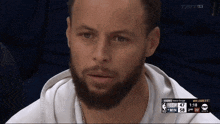 a man with a beard is sitting in front of a tnt sports screen