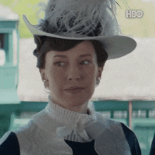 a woman wearing a hat with feathers and a hbo logo