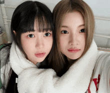 two girls are posing for a picture and one is wearing a shirt that says y.
