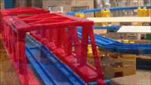 a toy train track with a red bridge and blue tracks