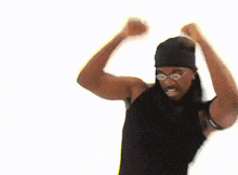 a man wearing a black tank top and a black headband is dancing