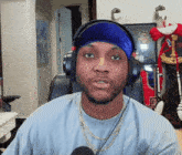 a man wearing headphones and a blue headband with the letter b on it