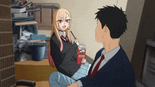 a girl sitting next to a man holding a box of pocky sticks