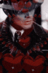 a man in a suit and tie is surrounded by red hearts .