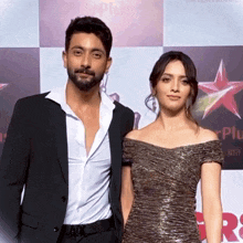 a man in a suit and a woman in a dress pose for a picture