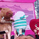 a group of people taking pictures of stuffed animals with a tiktok watermark on the bottom right