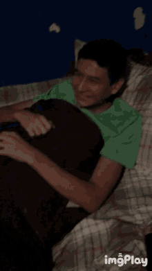 a man in a green shirt is laying in bed