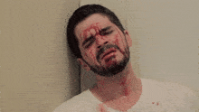 a man with blood on his face and neck is laying on the floor