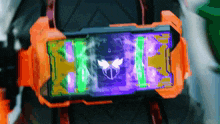a cell phone with a purple and green screen and a skull on it