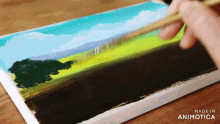 a person is painting a landscape on a canvas with the words made in animotica on the bottom