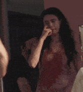 a woman covering her mouth with her hand while a man holds her hand