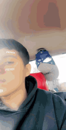 a man wearing a black hoodie with fendi written on his forehead