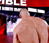 a man stands in front of a large red sign that says able