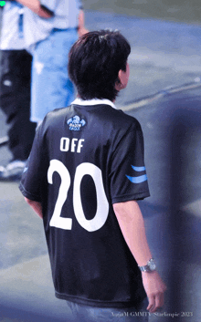 a man wearing a black jersey with the number 20 on it
