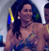 a woman in a bikini top is smiling while holding a light .