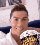 a man is smiling while holding a frozen piss beer