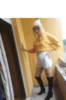 a woman wearing a yellow hoodie and white shorts