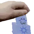 a hand is holding a stack of blue blocks with a face on them .
