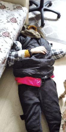 a person laying on the floor wearing a black vest