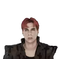 a man with red hair is wearing a black jacket with a cross on it