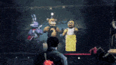 a man is standing in front of a stage with stuffed animals on it and one of them has the number 66 on it