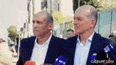 two men standing next to each other with a gifrun.com watermark on the bottom