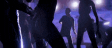 a group of people are dancing in a dark room at a nightclub .