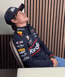 a man wearing a red bull shirt is sleeping