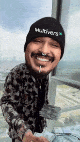 a man wearing a beanie that says multivers holds a stack of money
